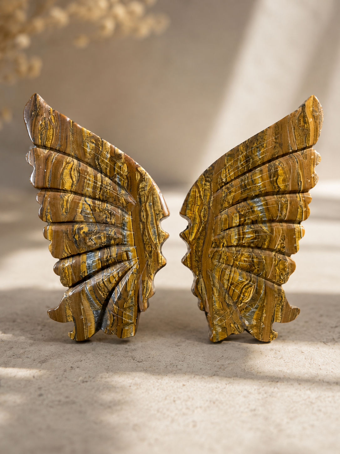 Tiger Iron crystal wing carving with golden-brown and metallic banding